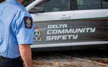 Community Safety Officer in uniform, by branded vehicle